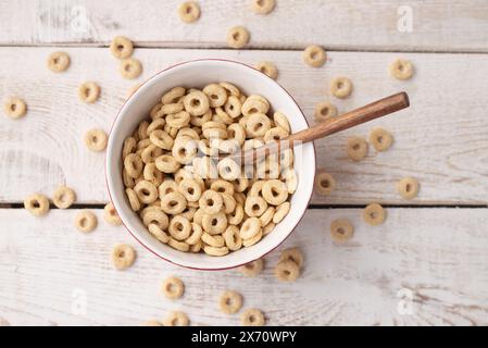 healthy cereal rings on a light wood background in a plate and scattered on the table. morning eat. Healthy children's breakfast. Dry muesli Stock Photo