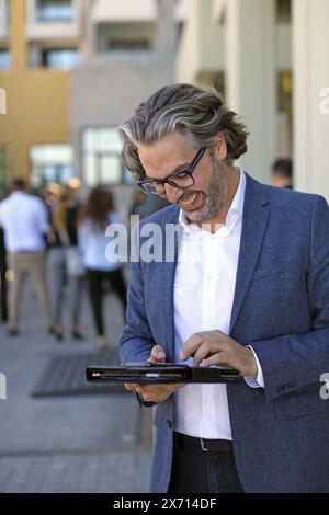 Business man writing message using  smart phone outside office Stock Photo