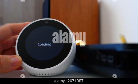 Paris, France - Jun 5th, 2020: A loading message is displayed on the Amazon Alexa screen during the initial setup of the smart assistant from Amazon Corporation, indicating the device's progress in preparing for use Stock Photo