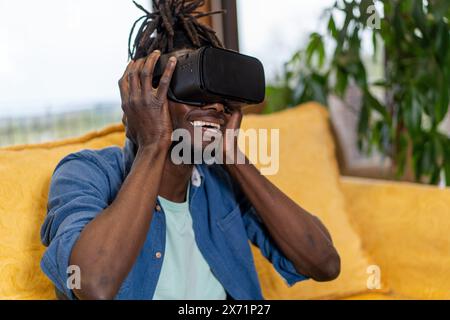 Man using VR headset - experiencing virtual reality - immersive technology - VR gaming, futuristic entertainment - technology innovation, home setting Stock Photo
