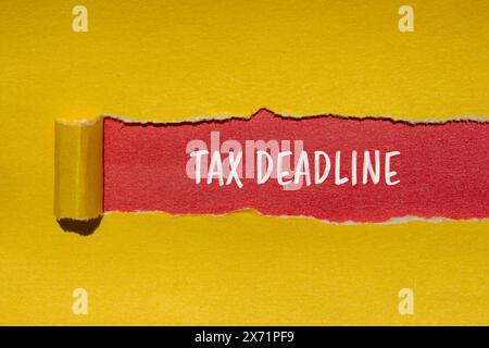 Tax deadline words written on ripped yellow paper with red background. Conceptual tax deadline symbol. Copy space. Stock Photo