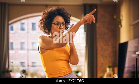 Portrait of Multiethnic Young Black Female Dancing in Comfy Casual Clothes, Having Fun at Home in Loft Apartment. Recording Funny Viral Videos for Social Media. Close Up Shot. Stock Photo