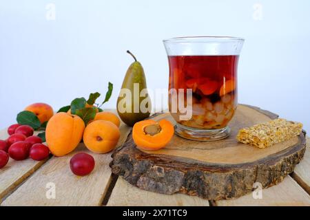 fresh juice fruit and berry low-calorie dessert in glass with bubble tea, ripe apricots, cherry plums, pears, muesli bar, concept of healthy eating, v Stock Photo
