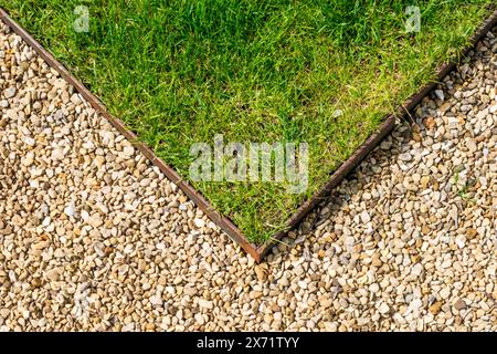 Neat metal lawn edging adjoining a gravel path. Stock Photo