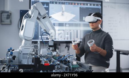 Asian Student Testing Interface of Bionic Hand. Engineer Wearing Virtual Reality Headset and Using Controllers at Modern University of Technology Classroom. Virtual Reality Concept. Stock Photo