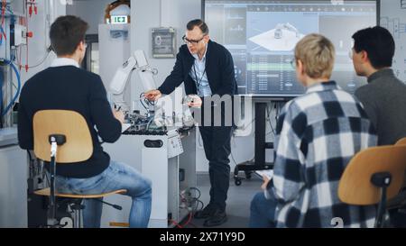 University Robotics Class. White Male Teacher Explaining Engineering to Students Using Robot Arm. Diverse Group of Young Engineers Sitting at University. Computer Science Education Build, Design Stock Photo