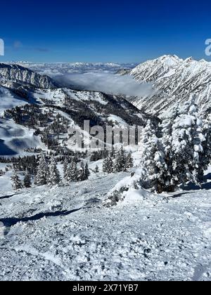 Scenic winter forest hills with mountains in the clouds at ski resort sunny day Stock Photo