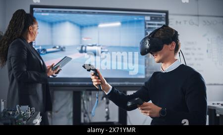 Black Teacher Typing on Tablet and Supervising While Her Student Wearing VR Headset and Using Controllers. Virtual Reality Technology For Industrial Design, Development, Prototyping in CAD Software. Stock Photo