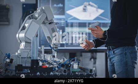 Unrecognisable Male Student Holding Virtual Reality Controllers, Uses New Technology for Industrial Design, Development, Prototyping in Robotics. High Tech Concept In Modern University Classroom. Stock Photo
