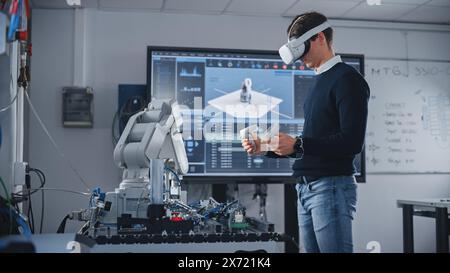 Student Engineer Using Virtual Reality Software for His Project. Man with Headset and Controllers Studying at Modern University in Classroom. Futuristic and High Tech Concept. Stock Photo