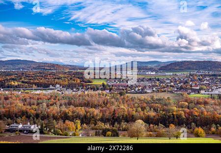 Autumn view over the Swiss landscape from a viewpoint. Several cities and villages visible. The Alps with snow in the background. Beautiful partally c Stock Photo