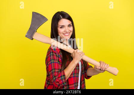 Photo of strong funny lady dressed checkered shirt holding sharp axe isolated yellow color background Stock Photo