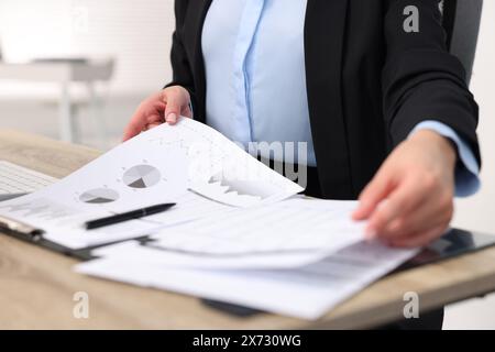 Secretary doing paperwork at table in office, closeup Stock Photo