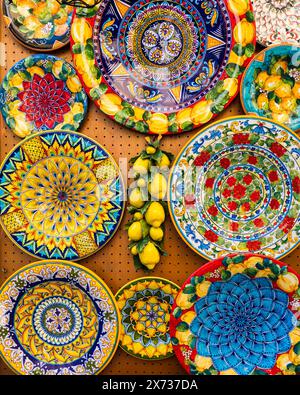 Collection of colorful Italian ceramic pottery, local craft products from Positano, Italy. Ceramic plates display in Positano, Italy. Colorful of vint Stock Photo