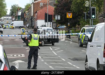 Clevedon Road, Birmingham, May 17th 2024 - West Midlands Police have closed several roads in the Balsall Heath area of Birmingham after a police chase led to the fleeing driver of a Nissan Micra to crash into another vehicle. One male occupant of the Micra was seriously injured and taken to hospital under arrest. Two other men fled the scene, one was arrested a short time later and the other is outstanding. Officers flooded the area of Clevedon Road and Lincoln Street setting up a large cordon. A mens trainer and black jacket along with first aid could be seen on the road at a pedestrian cross Stock Photo