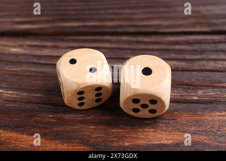Two game dices on wooden table, closeup Stock Photo