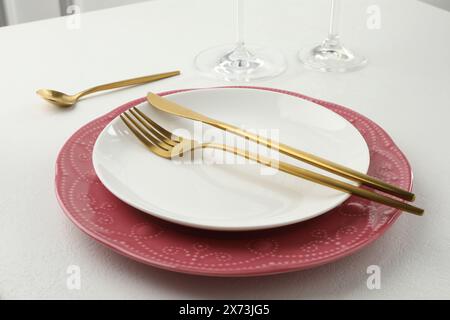 Stylish setting with cutlery and plates on white textured table Stock Photo