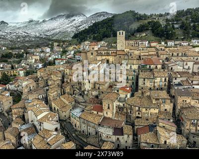 Aerial view of the ancient medieval village of Castel del Monte with the snow-capped Gran Sasso chain behind it. Castel del Monte,Abruzzo Stock Photo