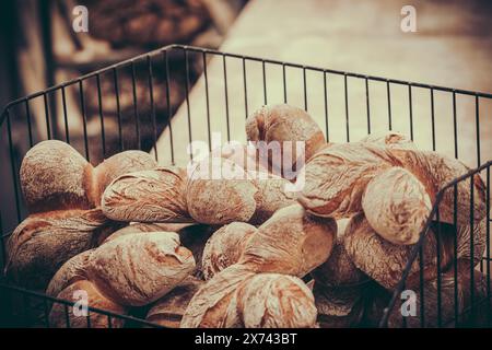 Freshly baked buns in a black metal basket. Stock Photo
