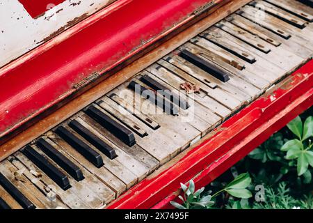 Close up of an old red piano with shabby keys on the street in London Stock Photo