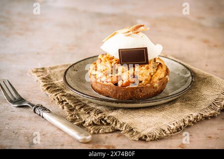 Tartlet made from crispy dough with apple and sprinkles and a topping of white cream, copy space Stock Photo