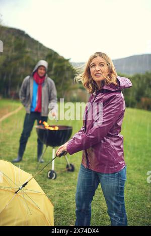 People struggle with umbrella in a rain caused by Typhoon Bavi in ...