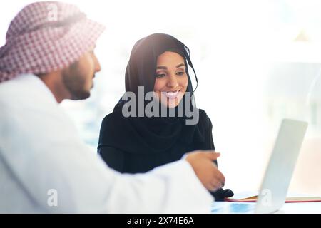 Muslim, people and coworking teamwork on project and mentor help on laptop in Dubai office. Arab, man and woman in business learning, training or Stock Photo