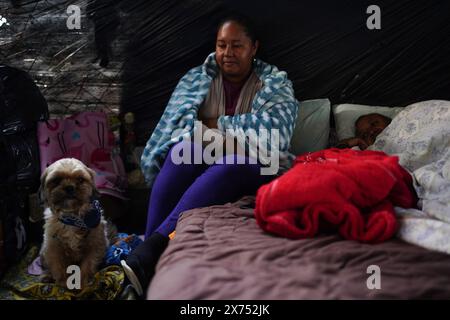 Canoas, Brazil. 17th May, 2024. A woman looks at an attentive dog while her husband lies next to her in the emergency shelter on the Ulbra University campus. According to the civil defense, almost 540,000 people had to leave their homes due to the floods and more than 76,000 people had to be accommodated in emergency shelters. Credit: Carlos Macedo/dpa/Alamy Live News Stock Photo