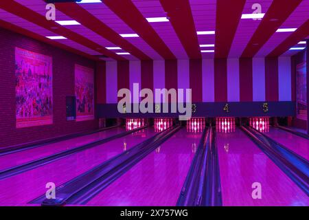View of bowling alley interior with pins set up and five lanes under illuminated lighting. Sweden. Stock Photo