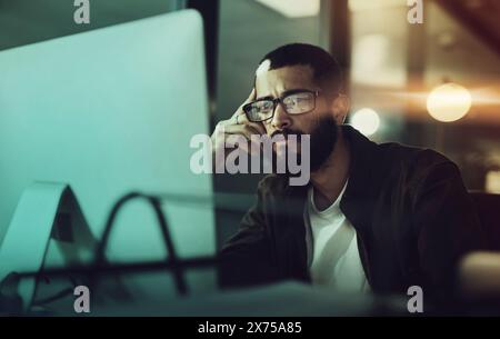 Computer, night and man by desktop with thinking for working overtime, proposal review and internet research. Male programmer, coding language and pc Stock Photo