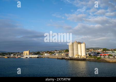 Cement silos with town of Devonport in background, Mersey River, Devonport, Tasmania Stock Photo