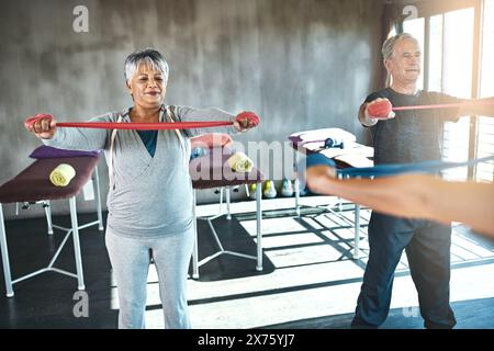 Stretching band, physiotherapy and senior people for support and help with muscle fitness by physiotherapist. Exercise, workout and strength training Stock Photo