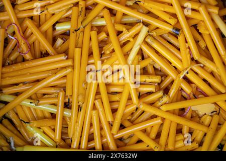A pile of used candles in a container near an altar in a Buddhist temple Stock Photo