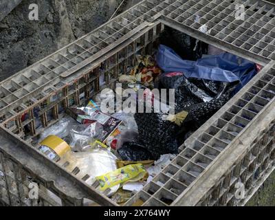 Jakarta, Indonesia - May 10, 2024 : Unsanitary trash cans contain a lot of rubbish that cannot be accommodated because the place has holes Stock Photo
