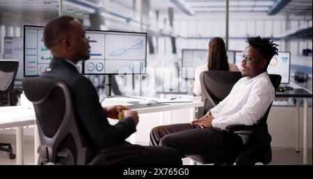 Two Businesspeople Talking With Each Other At Office Stock Photo