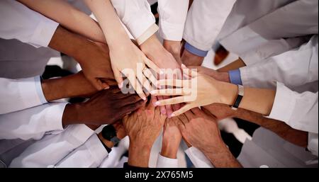 Medical Team Stacking Hands Against In Hospital Stock Photo