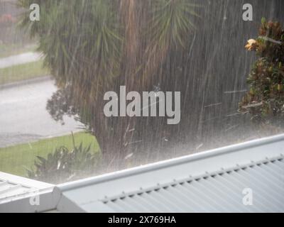 Heavy torrential rain falling onto a rooftop and bouncing up off it Stock Photo