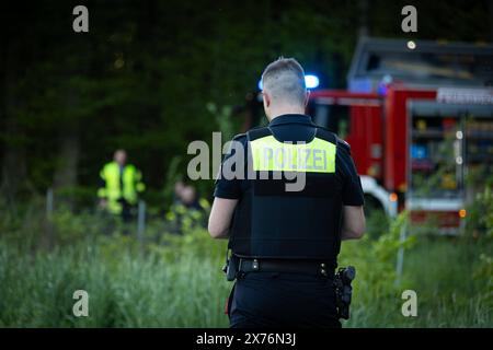 Melle, Deutschland 02. Mai 2024: Ein Polizist mit dem Aufdruck Polizei auf der Weste, steht vor einem Feuerwehrwagen mit Blaulicht. Landkreis Osnabrück Niedersachsen *** Melle, Germany 02 May 2024 A police officer with the word Polizei printed on his vest stands in front of a fire engine with flashing blue lights in the district of Osnabrück, Lower Saxony Copyright: xFotostandx/xGelhotx Stock Photo