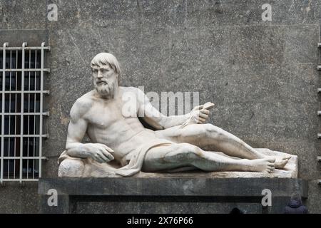 Florence, Italy - September, 01, 2022: reclining stone statue on gray wall Stock Photo