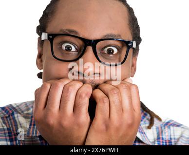 Portrait of an anxious young man biting his nails fingers freaking out Stock Photo