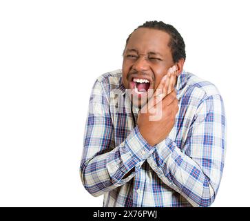 Closeup portrait handsome young man touching face having really bad pain tooth ache isolated on white background Stock Photo