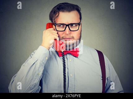 Closeup portrait of a serious grumpy looking business man talking on telephone Stock Photo
