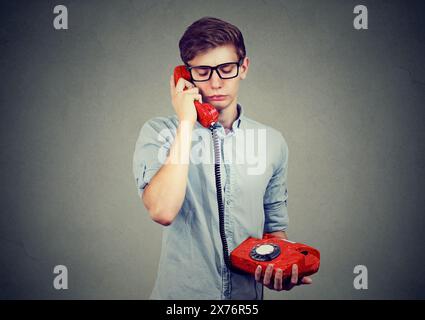 Portrait of a sad man talking on a telephone Stock Photo