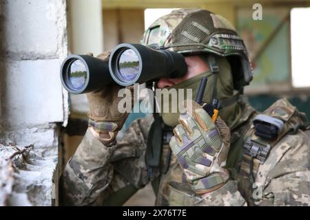 Military mission. Soldier in uniform with binoculars inside abandoned building Stock Photo