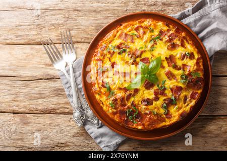 Frittata with chicken, cheese, eggs, bacon and herbs close-up in a plate on the table. Horizontal top view from above Stock Photo