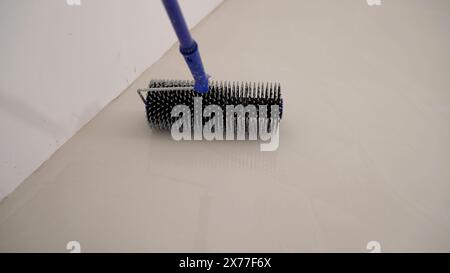 Workers pour self-leveling floor. Pouring Self-Leveling Floors. Self-Leveling Floors On A Large Area, A Worker. Self-leveling epoxy. Leveling with a Stock Photo