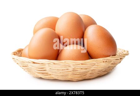 Front view of brown chicken eggs in stack in wicker basket is isolated on white background with clipping path. Stock Photo