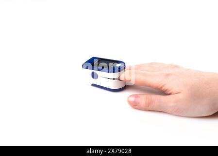 Close up of Finger and hand in an Oximeter Device. Pulse oximeter on white background Stock Photo