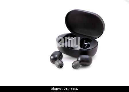 Wireless headphones isolated on a white background. Headset close up in the charging case close-up Stock Photo