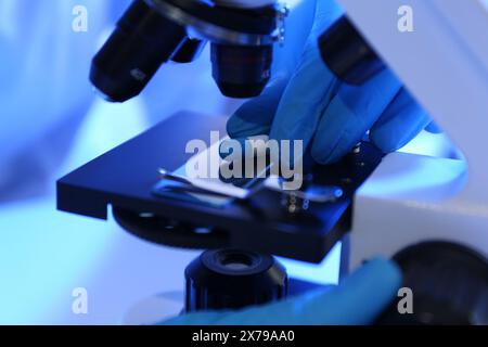 Scientist examining pill under microscope in laboratory, closeup Stock Photo